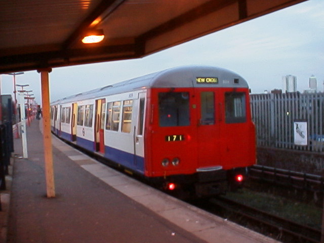 A stock train waits at New Cross
